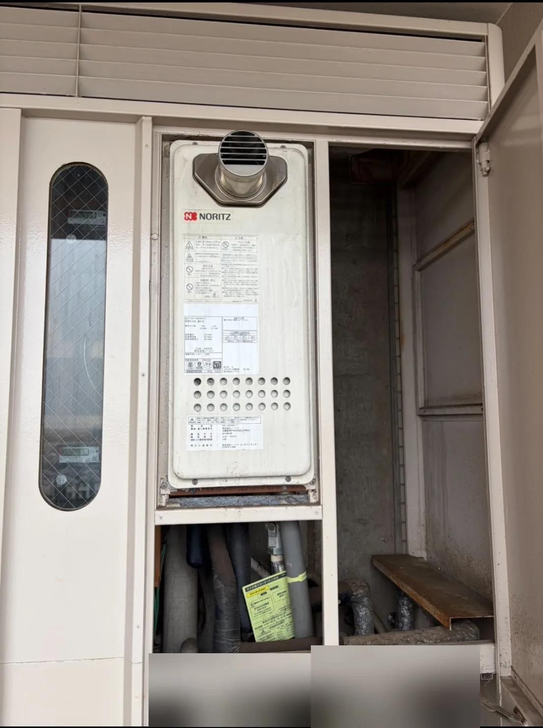 交換前の給湯器本体。パイプシャフトの中に設置されています。
