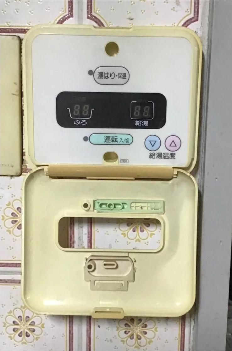 交換前の台所リモコン。隣のスイッチ板と並べて壁に取り付けられていた