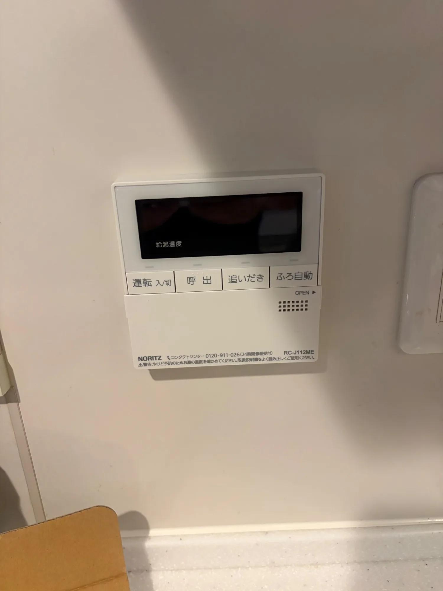 台所リモコンの交換後（RC-J112ME）。「給湯温度」の表示が出ており、運転入/切・呼出・追いだき・ふろ自動のボタンで操作できる