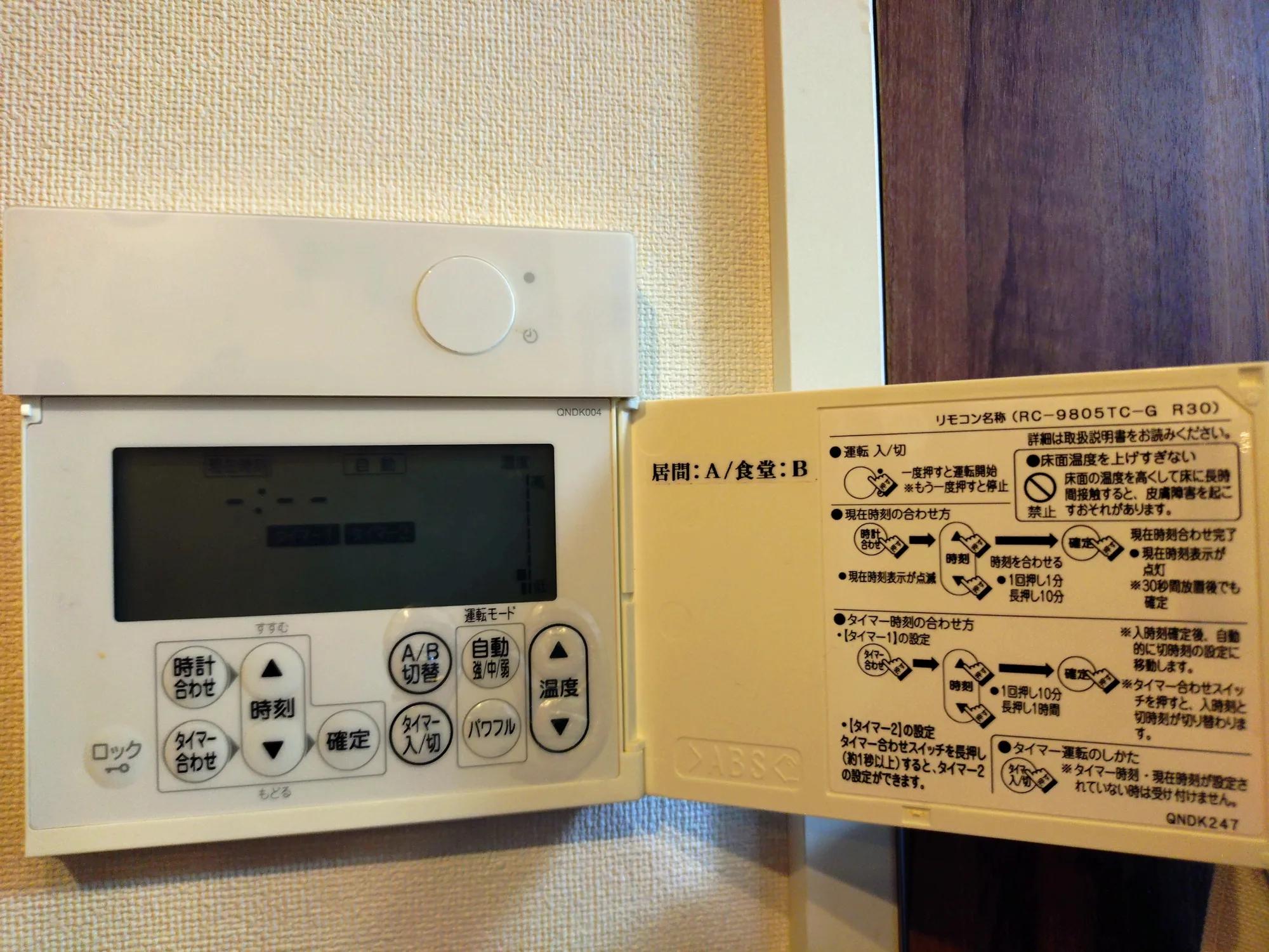 床暖房リモコンの交換前。壁に取り付けられた既設のリモコンで、この状態から入れ替えている
