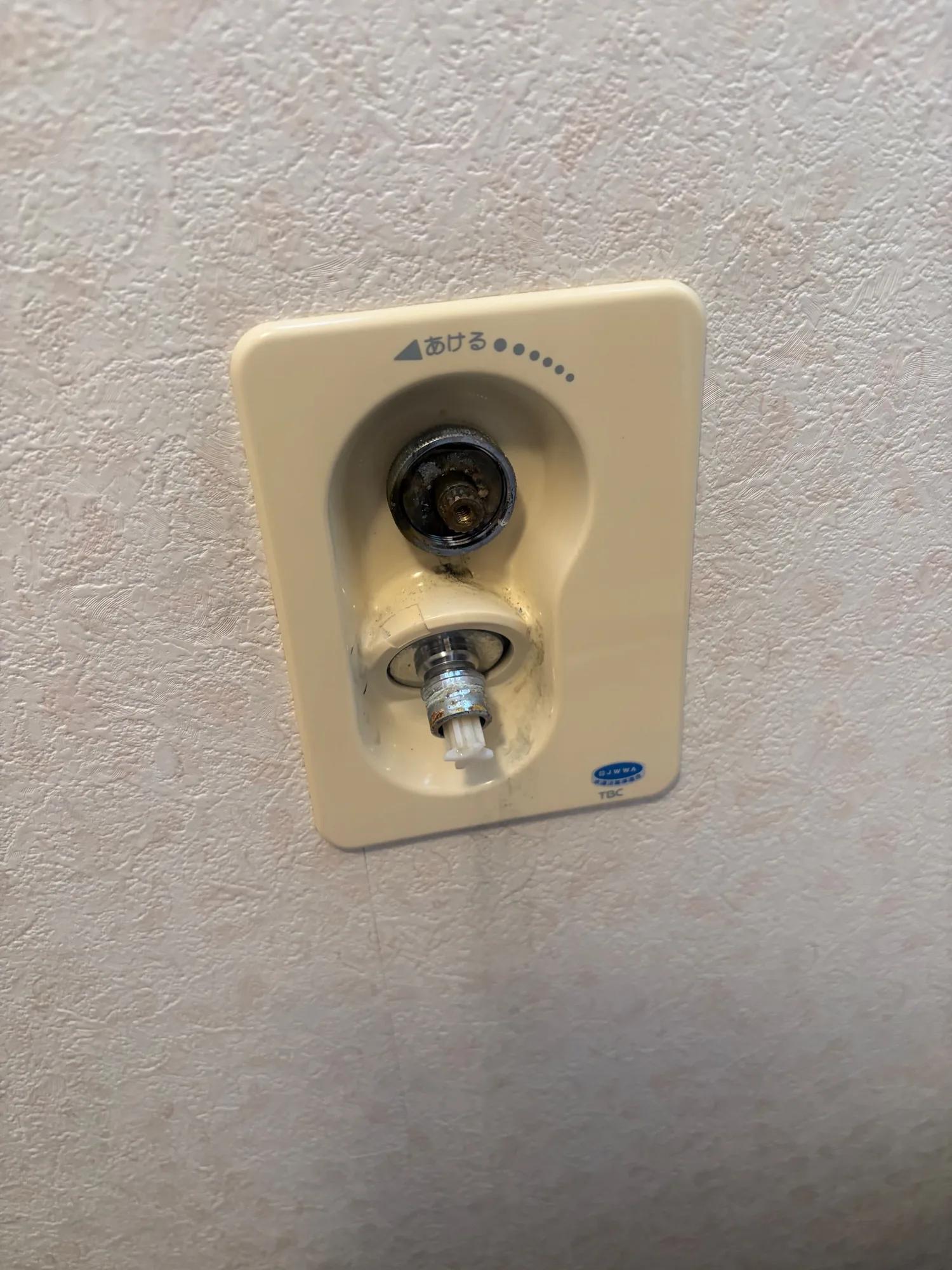 既設の洗濯機用水栓。ハンドルを外したところで、水栓の本体は壁の中に収まっている埋め込み型。表のカバーに型番の表示は見当たらない