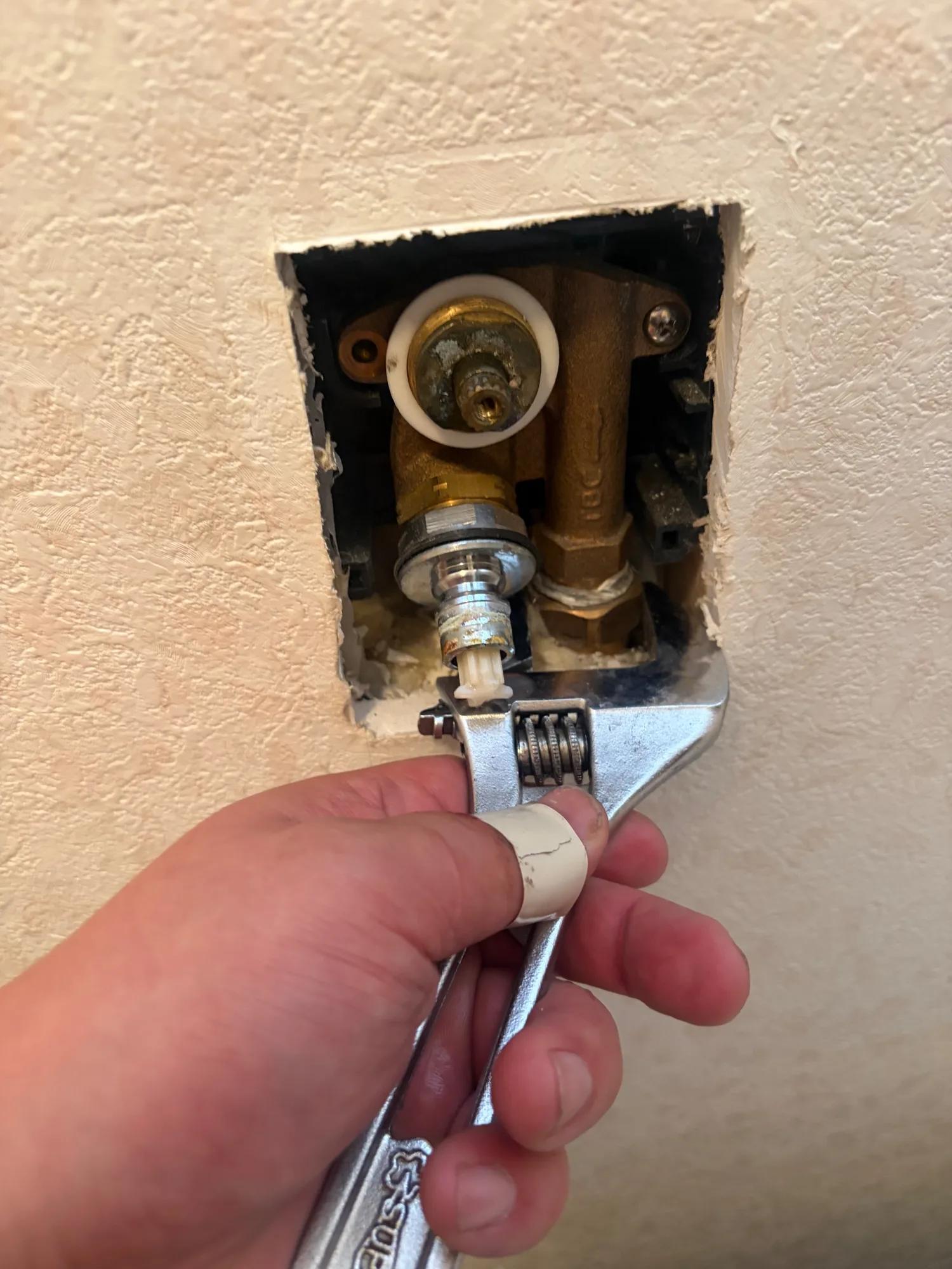 水道を止めて水を抜いたうえで、給水管とのつなぎ目をモンキーで外しているところ。手前に持っているのは外した部品