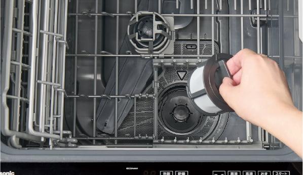 パナソニック食洗機の庫内。3層構造の残さいフィルターを手で取り外しているところ
